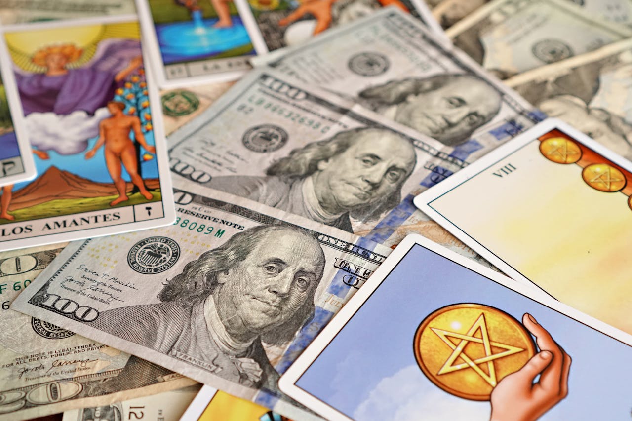 Tarot cards placed among hundred dollar bills depict fortune and wealth themes.